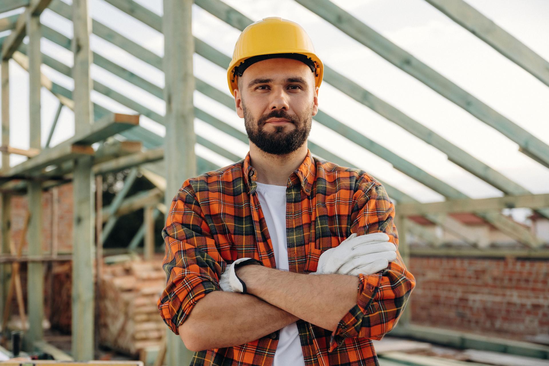 Handsome man, portrait. Construction worker is on the roof of a house